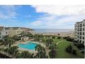Gorgeous aerial view of resort community pool, residences, and beach access at 8000 Palmetto Dr # 506, Isle of Palms, SC 29451