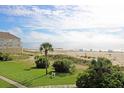 Scenic ocean view with sandy beach, blue umbrellas, and beautiful dunes from elevated lot at 8000 Palmetto Dr # 506, Isle of Palms, SC 29451