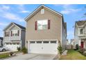 Home exterior features a spacious two car garage, beige siding, and trimmed lawn at 9009 Cat Tail Pond Rd, Summerville, SC 29485