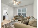 Bright living room featuring stylish sofas, a glass coffee table, and large window at 9009 Cat Tail Pond Rd, Summerville, SC 29485
