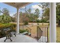 Inviting front porch with classic columns and a decorative bench, offering a relaxing outdoor space with neighborhood views at 105 S Palmetto St, Summerville, SC 29483