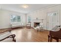 Bright living room with hardwood floors, fireplace, classic trim, and natural light from large windows at 105 S Palmetto St, Summerville, SC 29483