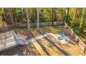 Aerial view of backyard with a stone fire pit and two blue Adirondack chairs surrounded by a wooded perimeter at 1253 Lakefront Dr, Charleston, SC 29412