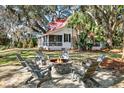 Inviting backyard with a brick fire pit surrounded by Adirondack chairs at 127 Oak St, McClellanville, SC 29458