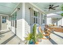 Charming front porch features rocking chairs and a ceiling fan for a relaxing outdoor space with views of the neighborhood at 142 Midtown Ave, Summerville, SC 29486