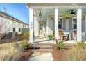 Inviting front porch with rocking chairs, hanging plants, and brick steps showcasing the entrance to the charming home at 142 Midtown Ave, Summerville, SC 29486