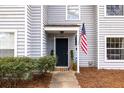 Welcoming townhouse entrance featuring a dark door, green shrubs, and an American flag at 1662 Hunters Run Dr, Mount Pleasant, SC 29464