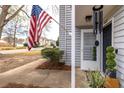 Quaint townhouse porch featuring an American flag, dark door, and lush greenery at 1662 Hunters Run Dr, Mount Pleasant, SC 29464