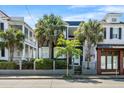 Charming two-story home featuring a small balcony, palm trees, and beautiful landscaping at 167 Spring St # A/B, Charleston, SC 29403