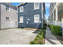 Concrete parking area beside a blue two-story house with white trim and a walkway at 167 Spring St # A/B, Charleston, SC 29403
