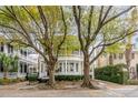 Charming home with double porches nestled behind mature trees on a picturesque street at 18 Logan St, Charleston, SC 29401