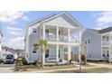 Inviting two-story home with a charming double front porch and a well-kept front yard at 225 Bird Song Path, Summerville, SC 29485