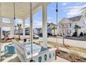 Cozy porch swing invites relaxation on this charming street with lovely homes and manicured lawns at 225 Bird Song Path, Summerville, SC 29485