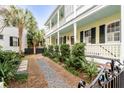 Charming yellow house with a long front porch, black shutters, and landscaped yard at 25 Logan St, Charleston, SC 29401