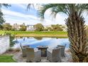 Scenic backyard featuring a seating area with a fire pit overlooking a serene waterway and golf course at 27 Ocean Point Dr, Isle of Palms, SC 29451
