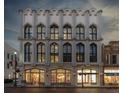 Beautiful white building showcasing multiple arched windows and inviting storefronts with sidewalk at 71 Wentworth St # 302, Charleston, SC 29401