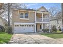 Welcoming two-story house with a charming front porch, green lawn, and convenient attached two-car garage at 8475 Athens Way, North Charleston, SC 29420