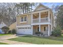 Inviting two-story home featuring a cozy front porch, lush green lawn, and an attached two-car garage at 8475 Athens Way, North Charleston, SC 29420