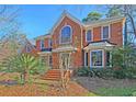 Elegant brick home featuring a grand arched window and meticulously maintained landscaping at 8614 Arthur Hills Cir, North Charleston, SC 29420