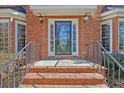 Close-up of a classic brick entrance with wrought iron railings and a glass-paneled front door at 8614 Arthur Hills Cir, North Charleston, SC 29420