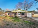 Charming single-story brick home featuring an attached garage and a cozy front porch at 100 Pine Ridge Dr, Goose Creek, SC 29445