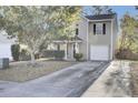Two-story home featuring neutral siding, black shutters, a one-car garage, and mature trees in a well-maintained yard at 112 Avonshire Dr, Summerville, SC 29483