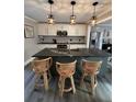 Open-concept kitchen features large granite island with seating and modern pendant lighting at 122 Mellard Dr, Goose Creek, SC 29445