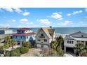 Coastal home with double garages and balcony offers picturesque ocean views, blending comfort and seaside charm at 1615 E Ashley Ave, Folly Beach, SC 29439