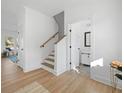Inviting foyer with wood-look floors, a staircase, and white walls, creating a bright and airy entrance at 1738 N N Hwy 52, Bonneau, SC 29431