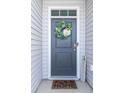 Inviting front door with a decorative wreath and a 'Welcome' sign, set in a light grey exterior at 202 Tall Grass Ct, Summerville, SC 29483