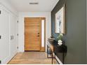 Warm foyer with hardwood floors, a striking wood door, and a decorative table at 2166 Welch Ave, Charleston, SC 29412
