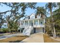 Inviting two-story home with a double front porch, white railings, and a neatly maintained lawn at 2514 Bullock Guard Dr, Johns Island, SC 29455