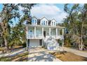Beautiful two-story house with a spacious front porch, white stairs, and a lovely landscaped yard at 2514 Bullock Guard Dr, Johns Island, SC 29455