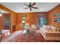 Inviting living room with wood paneled walls, ceiling fan and comfortable furniture at 2820 Jasper Blvd, Sullivans Island, SC 29482