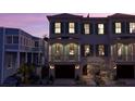 A townhouse with garage and lush landscaping is shown at dusk at 4 Trapman St # B, Charleston, SC 29401