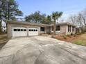 Charming brick home with a well-maintained lawn, mature trees and a two-car garage at 4341 Helene Dr, North Charleston, SC 29418