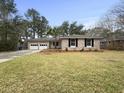 Charming brick home with a well-maintained lawn, mature trees and a two-car garage at 4341 Helene Dr, North Charleston, SC 29418