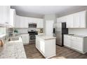 Bright kitchen boasts white cabinets, stainless steel appliances, granite countertops, and a convenient center island at 548 Richfield Way, Summerville, SC 29486