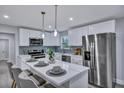 Modern kitchen featuring a large island with seating, stainless steel appliances, and stylish backsplash at 828 Longbranch Dr, Charleston, SC 29414