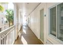 Bright hallway with white walls, doors, and a view of palm trees and the beach at 1004 Ocean Boulevard # 110, Isle of Palms, SC 29451