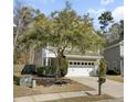 Two-story home with a two-car garage, a small porch, and mature landscaping at 110 Instructor Ct, Ladson, SC 29456