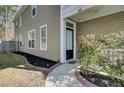 Inviting front entrance with a black door, landscaped flower beds, and a well-maintained walkway at 110 Instructor Ct, Ladson, SC 29456
