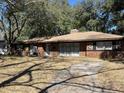 Inviting brick home featuring large windows, mature trees, and a well-maintained lawn at 111 Newington Rd, Summerville, SC 29485