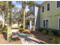 Exterior view of a lovely two-story home, showcasing the well-maintained yard and mature palm trees at 1225 Blakeway St # 403, Charleston, SC 29492
