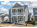 Two-story home featuring a gray exterior with white columns supporting the front porch and balcony at 127 Country Gate Ln, Summerville, SC 29485