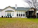 Rear exterior showcasing a well-maintained lawn, screened porch and many large windows at 1346 Ashley Gardens Blvd, Charleston, SC 29414