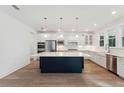 Well-lit kitchen featuring custom white cabinetry and a dark blue island with pendant lights at 1675 Cultivation Lane Dr # 458, Mount Pleasant, SC 29466