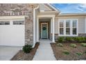 Inviting front entrance with a light blue door, brick accents, and manicured landscaping at 2014 Barn Swallow Rd, Summerville, SC 29483