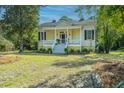 Attractive house with a welcoming front porch and well-maintained lawn at 207 S Gum St, Summerville, SC 29483