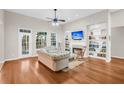 Bright living room featuring hardwood floors, fireplace, built-in shelves, and large windows at 2124 Tall Grass Cir, Mount Pleasant, SC 29466